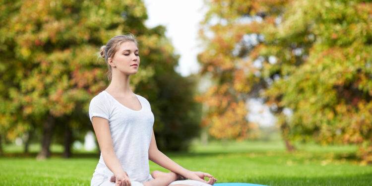 Young girl doing yoga in the park