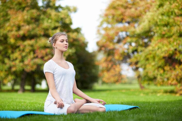 Young girl doing yoga in the park